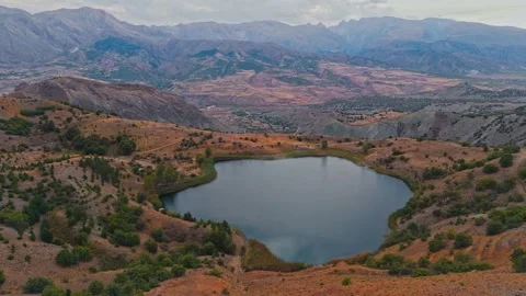 Lone lake mirrors distant mountains 스톡 동영상 332572858