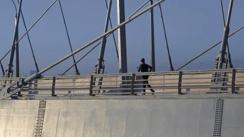 Lone male Runner Jogging Over The Industrial Transport Bridge in big winter City Stock Footage 102460307