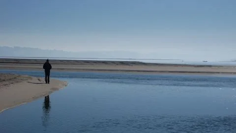 Lone Man on Beach by Estuary Stock Photos