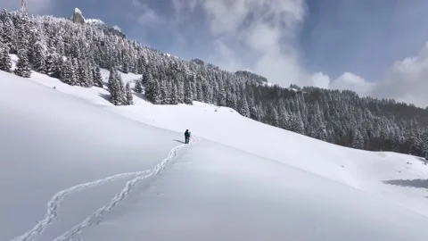 Lone man walking through snow. Mountain expedition. Epic Aerial steady view Stock Footage 205093885