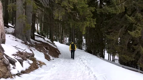 Lone man walking through snow. Mountain expedition. Epic Aerial steady view Stock Footage 205096736