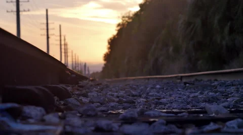 Lone man walks down railroad tracks into sunset, 4K Stock Footage 47261666