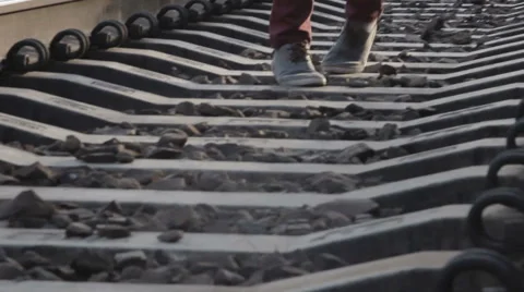 A lone man walks on the tracks Stockbeeldmateriaal 64902032