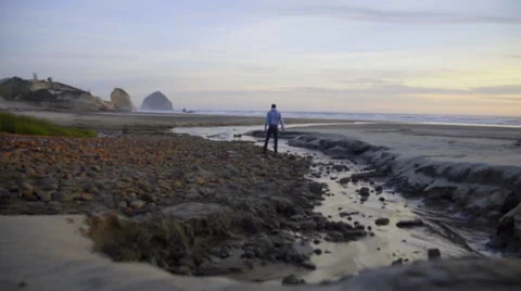Lone man wanders the beach Stock Footage 59898940