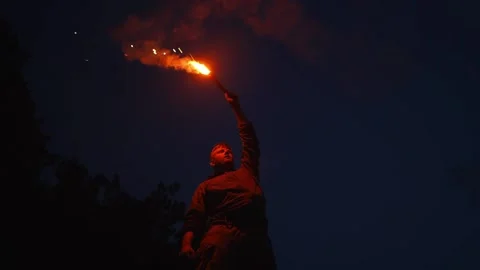 A lone man waving a red torch in the darkness Stock Footage 228883952