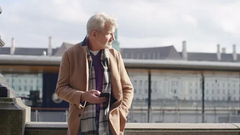 Lone mature man using his phone in the city outdoors Video stock 81870745