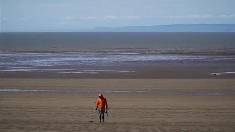 A lone metal detectorist on an empty beach Stock Footage 122319225
