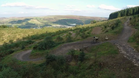 Lone mountain biker shredding some big berms, drone aerial 4K Stock Footage 101108003