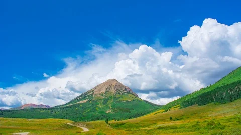 Lone Mountain With boulstering clouds Behind Jeep Road Time Lapse, Timelapse, Stock Footage 128943331