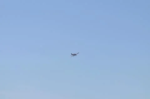 A lone plane in a blue, cloudless sky Stock Photos