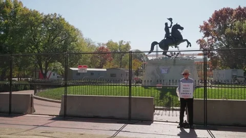 A lone protester stands at the White House fence beside Lafayette Square Stock Footage 345299508