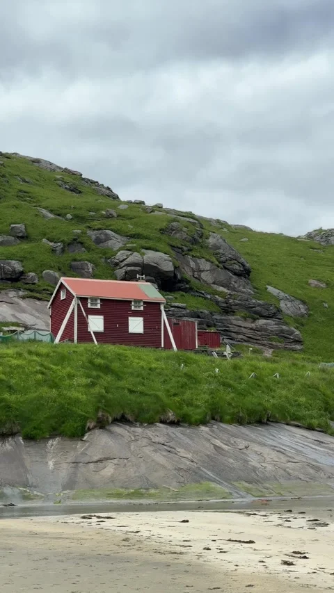 Lone red rorbu cabin by the shore near Bunes beach, Lofoten Islands, Norway Stock Footage 332887238