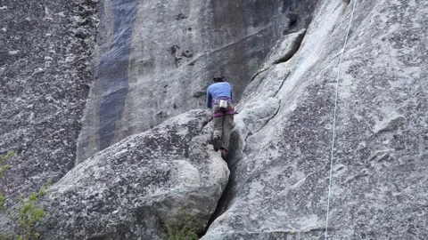 Lone rock climber scaling base of El Capitan with ropes, Yosemite Valley Stock Footage 241194092