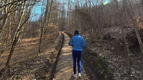 Lone runner moves through a quiet forest path. Kozji Kamen Viewpoint Видео 331872566