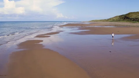Lone runner on quiet beach. Drone, 4K Stock Footage 89748163