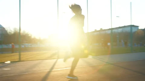 Lone runner sprinting toward camera at evening on an outdoor path on stadium Stock Footage 339205140