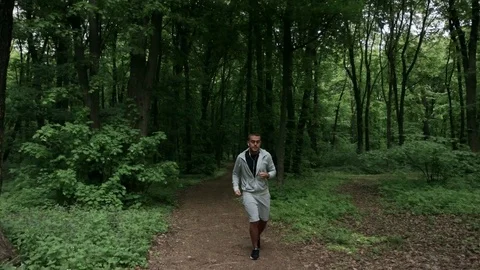 Lone runner in wintry wood, slow motion shot Stock Footage 75539324
