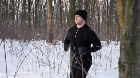 Lone runner in wintry wood, slow motion shot at 180fps Stock Footage 87920675