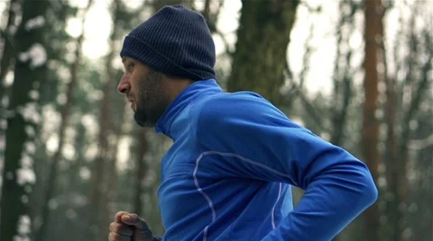 Lone runner in wintry woods, slow motion shot at 240fps Stock Footage