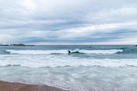 Lone Surfer on a Cloudy Beach Day Stock Photos