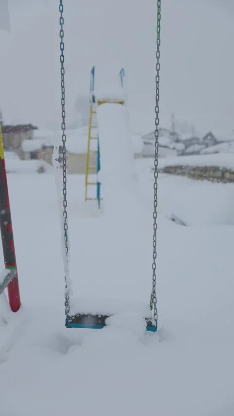 Lone swing and slide in heavy snow Video stock 327687722