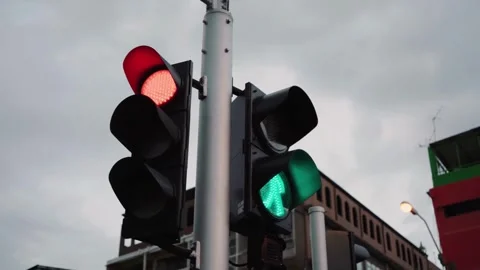 A lone traffic light changes from red to yellow to green in the downtown of a Stock Footage 256737789