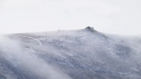 A lone walker on a snow-covered Hope Bowdler Hill, Shropshire, UK. March 3 2024 Video stock 278666789