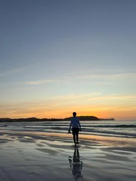 Lone walker on Sunset Beach Stock Photos