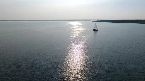A lone white sailboat floats on the sea Stock Footage