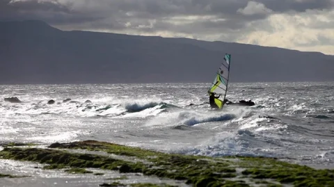 Lone windsurfer enjoying the thrill of the waves on a windy day. Stock Footage 88342905