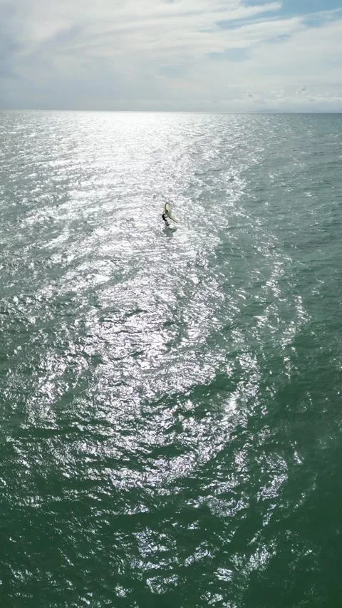 Lone Windsurfer Gliding on a Sunlit Ocean in Tuscany, Italy Video stock 335818828
