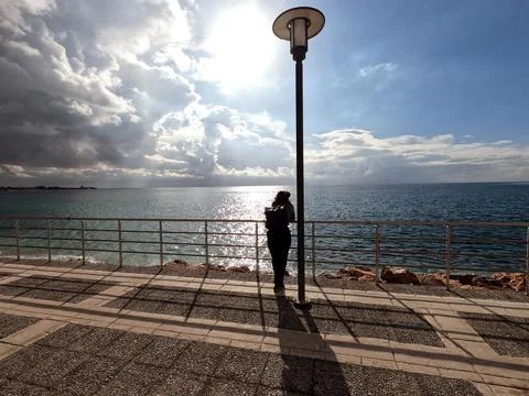 Lone woman enjoying the sea-view on a bright December day Stock Photos