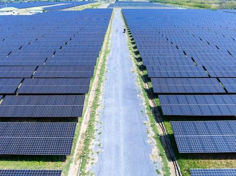 Lone Worker Driving Motorcycle Through Solar Panel Farm Rows High Angle Shot Photos