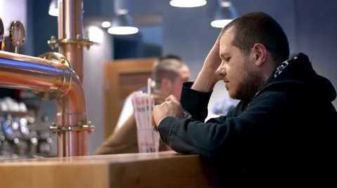 Lonely and depressed man drinking alcohol in a pub: desperate alcohol addicted Stock Footage