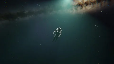 A lonely astronaut looking at something with a galaxy behind him Stock Footage 253568499