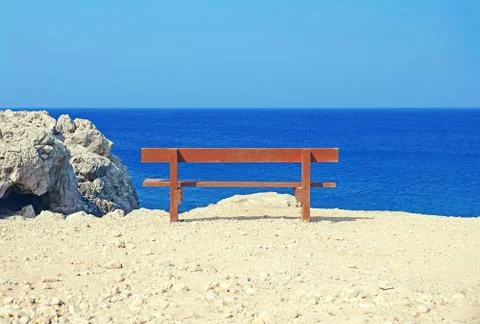 Lonely bench at the seashore Stock Photos