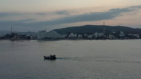 Lonely boat in the ocean close to island early in the morning dusk before sunris Stock Footage 124106973