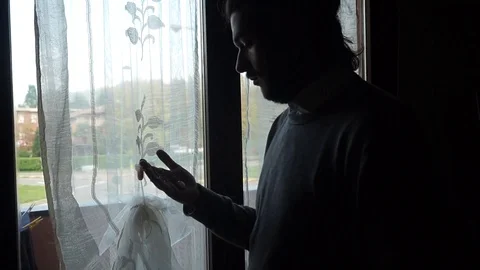 Lonely Boy is checking the time at the window Stock Footage 99138116