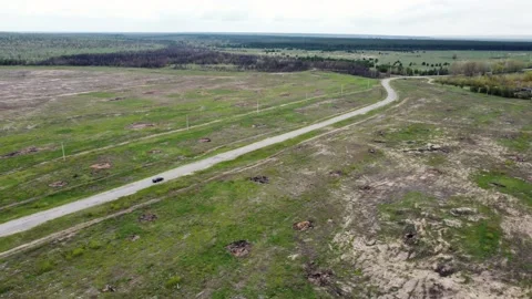 A lonely car drives along an empty road outside the city in the countryside Stock Footage 193976056