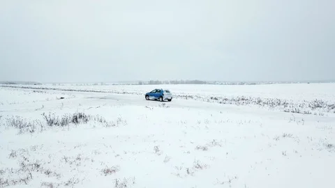A lonely car stands in the middle of a snow-covered field in winter. White Stock Footage 101714026