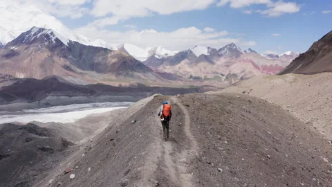 Lonely climber in mountaineering gear with backpack and trekking poles during Le Video stock 340111177