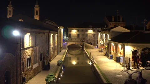 Lonely Cyclist Riding Down Comacchio Street at Dusk Stock Footage 296489695