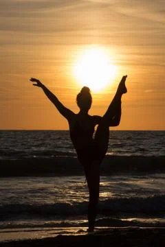 Lonely Dancer ballet posing on the beach sunset silhouette sea Stock Photos