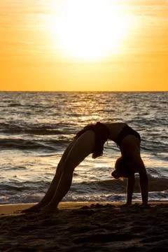 Lonely Dancer ballet posing on the beach sunset silhouette sea Stock Photos