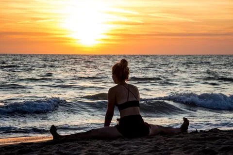Lonely Dancer ballet posing on the beach sunset silhouette sea Stock Photos