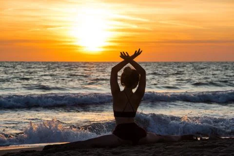 Lonely Dancer ballet posing on the beach sunset silhouette sea Stock Photos