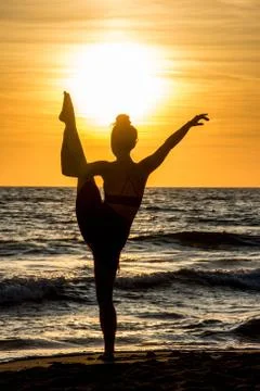 Lonely Dancer ballet posing on the beach sunset silhouette sea Stock Photos
