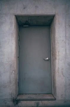 Lonely door deep inside a massive concrete wall Stock Photos