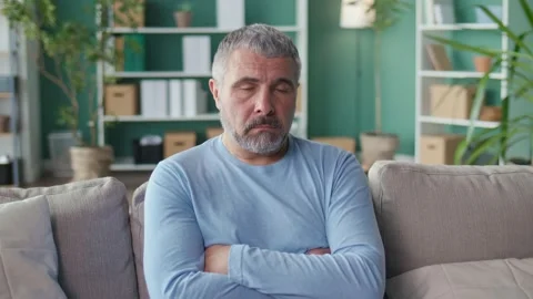 A Lonely Elderly Man Sitting on the Couch at Home, Feels Loneliness, Depression Stock Footage 166729705