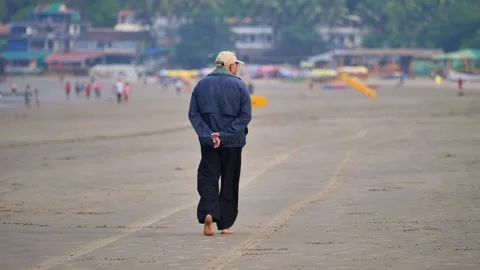 Lonely elderly man walking along the beach Stock Footage 265233368